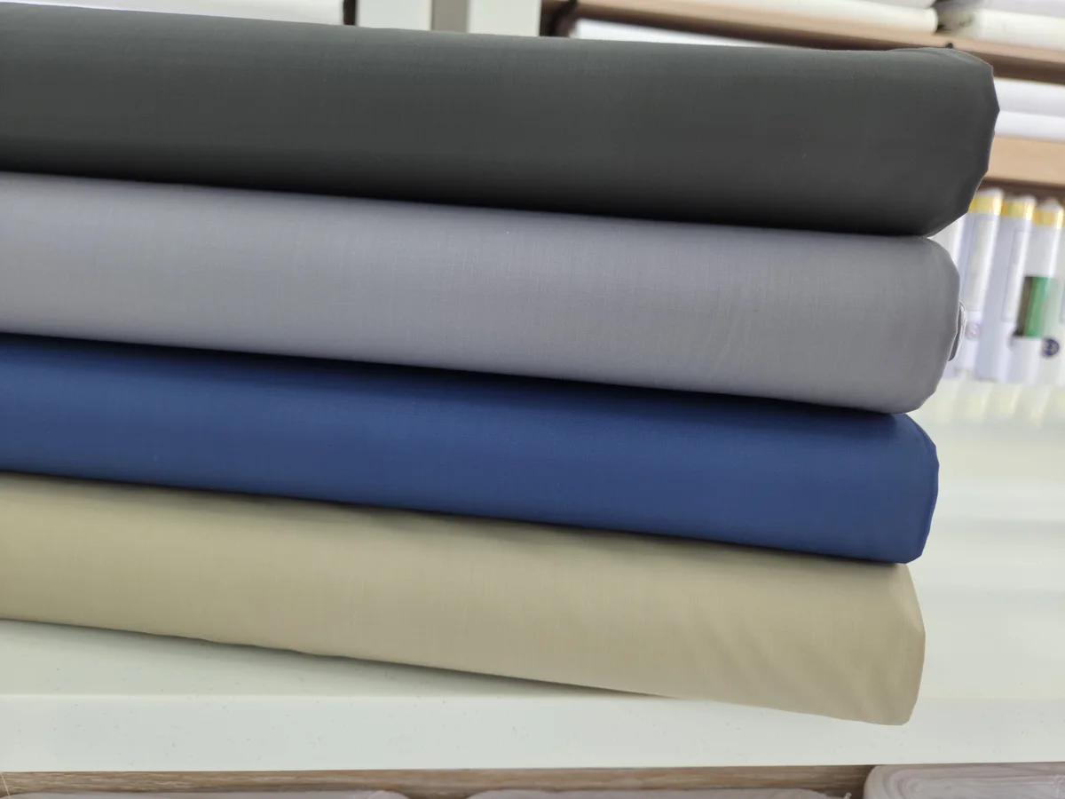 Stacked polyester rolls in charcoal, grey, blue and beige