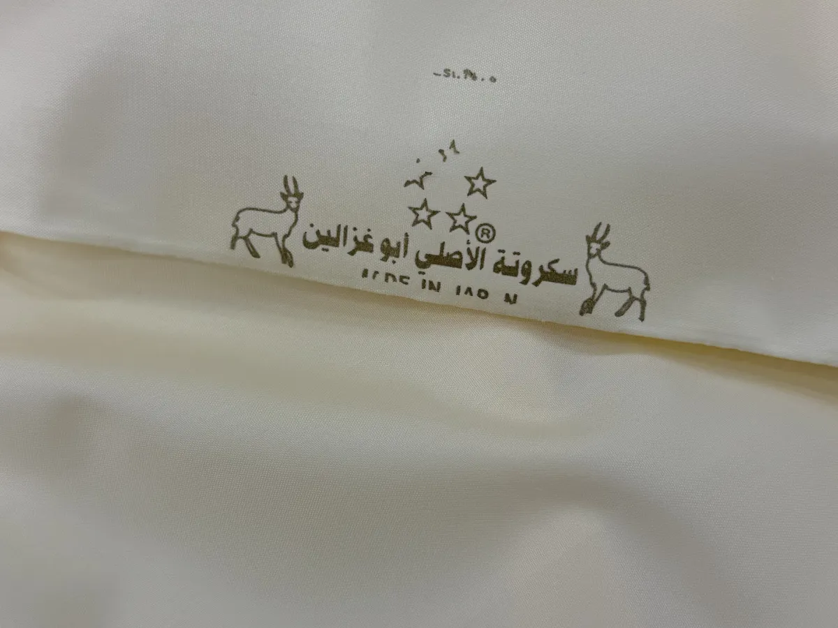 The gold “Original Sukruta — Abu Ghazalain” logo printed on the fabric
