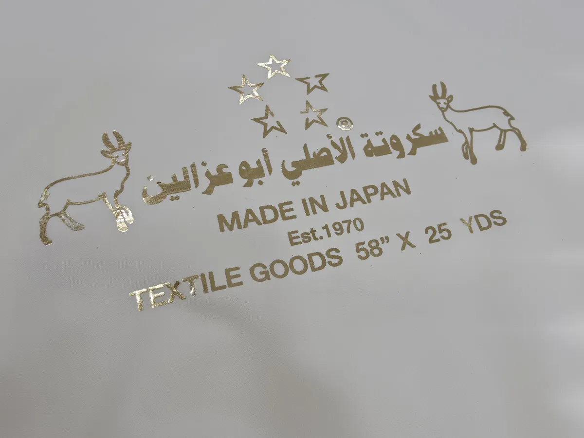 Gold Original Sukruta Abu Ghazalain logo with “Est. 1970” and “Made in Japan” on cream fabric