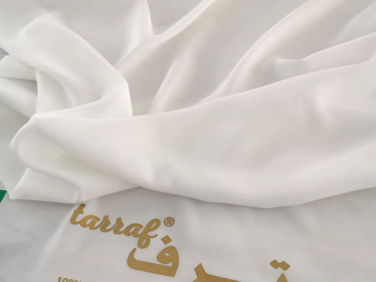 The “Tarraf — 100% polyester — Made in Japan” print on the fabric