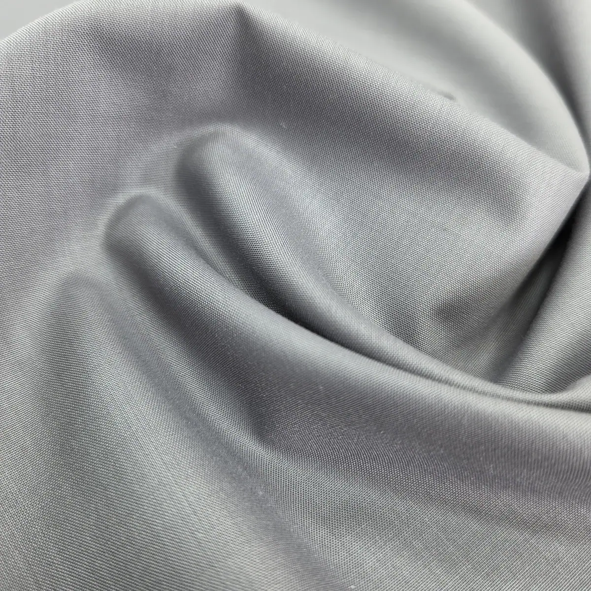 Light grey polyester fabric folded in soft folds