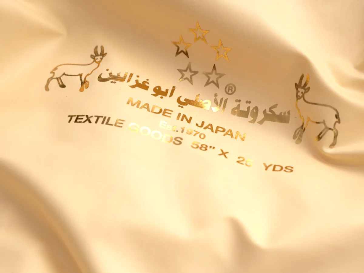 The gold “Original Sukruta Abu Ghazalain — Made in Japan” print on the fabric