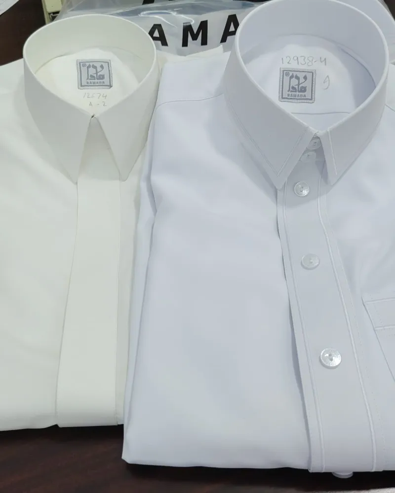 A white and a cream thobe, folded and ready for handover at Ramada Al-Raqi Tailoring