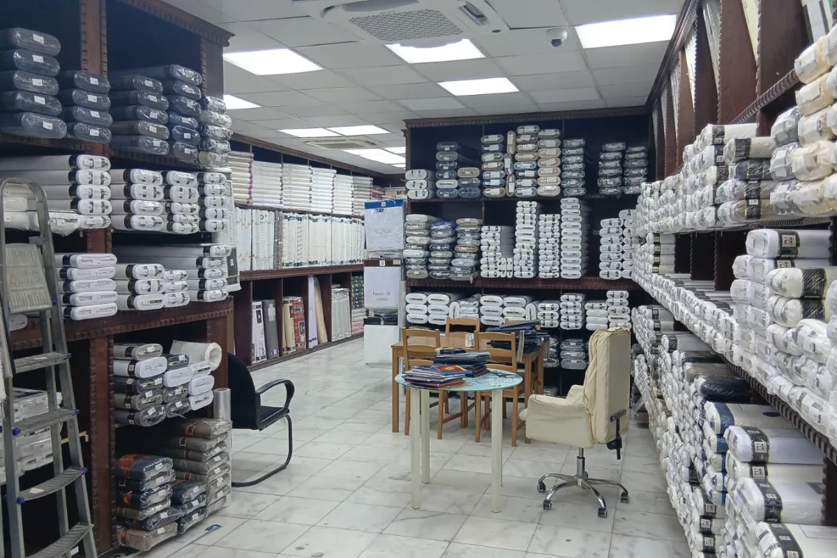Shelves of thobe-fabric rolls at the wholesale branch in Souq Al-Jamea